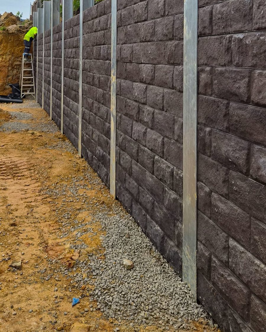 Reinforced block retaining wall built to height