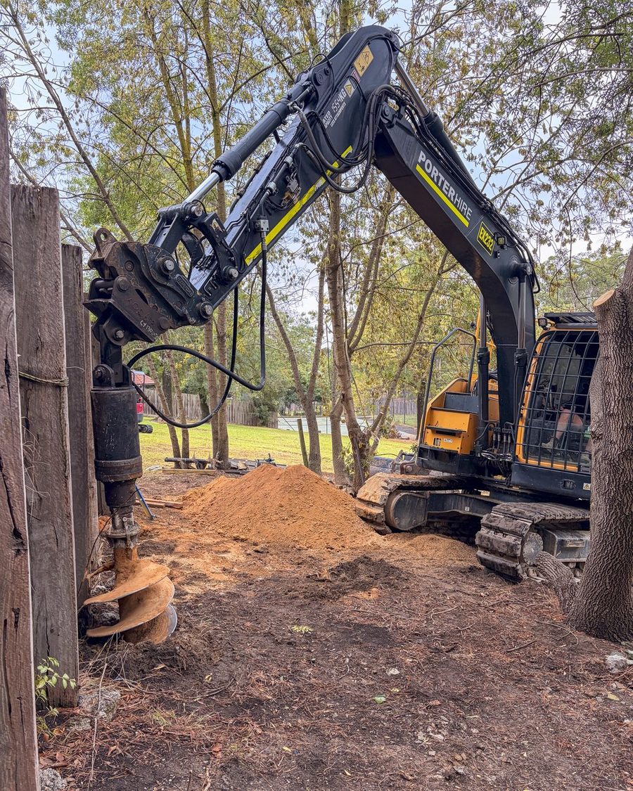 Auger drilling new footings alongside the failing wall
