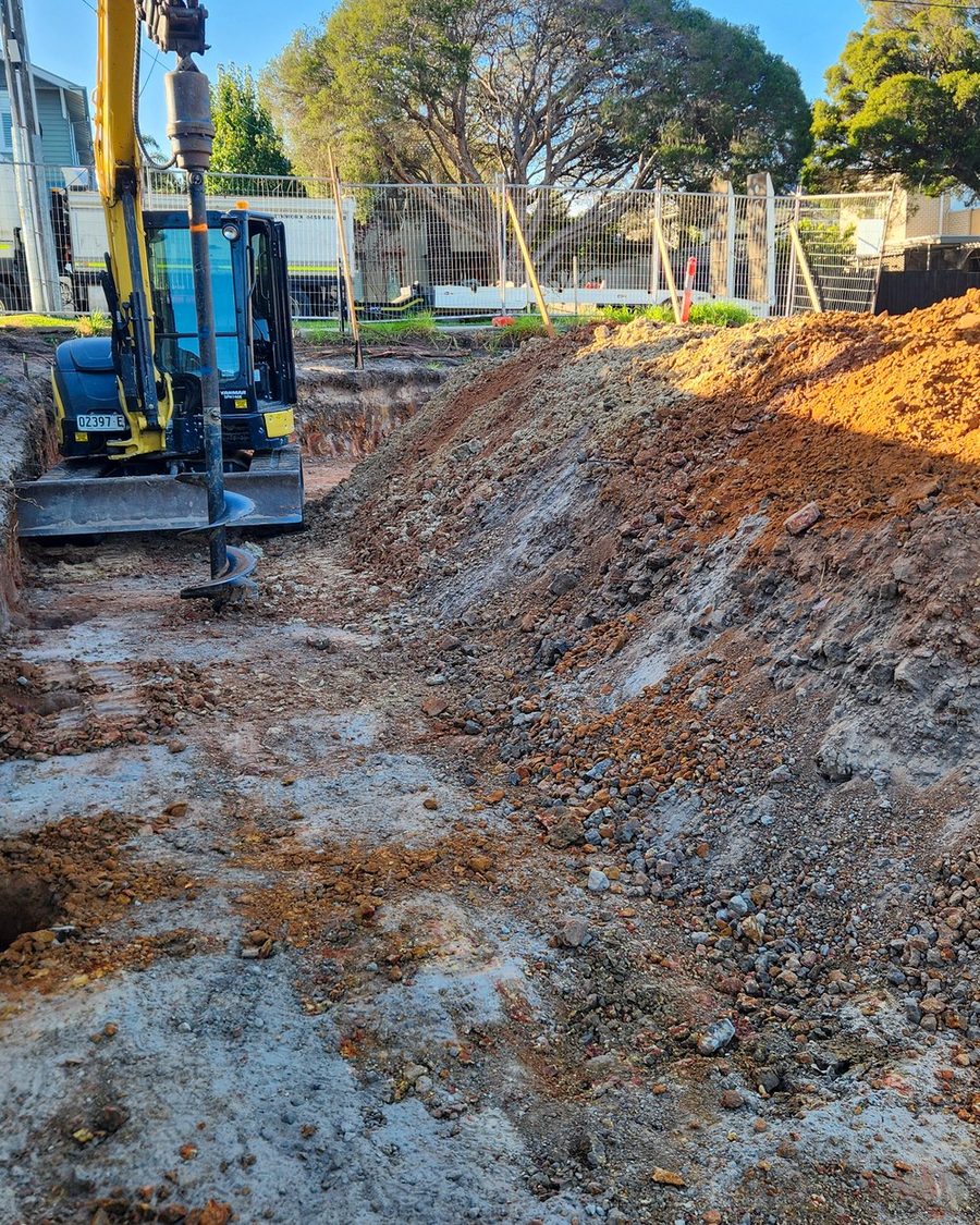 Excavation alongside a dwelling for a replacement retaining wall
